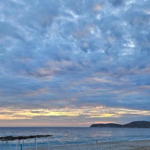 a beach with a cloudy sky and the ocean at SEA bed and restaurant 1 in Borsh