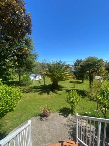 a garden with palm trees and a white fence at La Fincurri del Nando in A Coruña