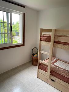 a room with two bunk beds and a window at La Fincurri del Nando in A Coruña