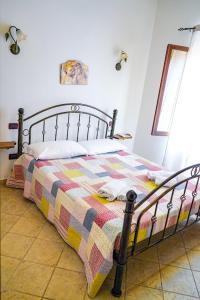 a bedroom with a bed with a colorful quilt on it at MAESTRALE B&B in Arbus