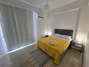 a bedroom with a bed with a yellow blanket at Lake View Apartment in Famagusta in Mağusa
