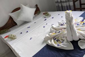 a white bed with towels and flowers on it at Lake View villa 2 BR near beach in Tangalle