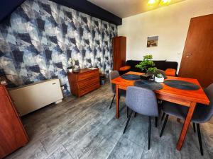 a dining room with a wooden table and chairs at Corso Apartman Hajdúszoboszló in Hajdúszoboszló +4 photos