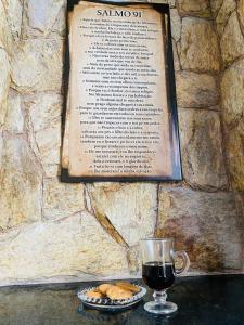 a glass of wine and cookies on a table with a book at Hostel Anprado 2 kit café incluso, Próx-Aeroporto de Guarulhos in Guarulhos +11 photos