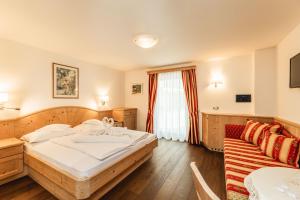 a hotel room with a bed and a couch at Hotel Daniel Apartments in Selva