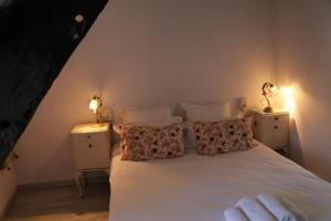 a bedroom with a white bed with two night stands at Le Poisson Ivre in Dinan