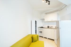 a kitchen with a yellow couch in a room at Mountain Apartments SuperSki in Cavnic