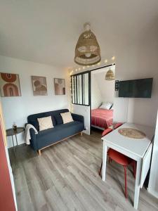 una sala de estar con un sofá y una cama en Studio Vue Mer, en Villers-sur-Mer
