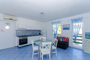 a kitchen and dining room with a table and chairs at Apartments Vidoni in Zastražišće