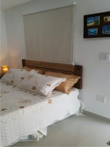 1 cama con sábanas blancas y almohadas en una habitación en Hospedaje solymar III Sarie Bay, en San Andrés