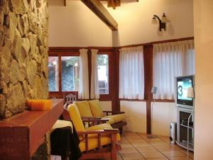 un soggiorno con sedie gialle e TV di Hosteria de las Piedras a Mar de las Pampas