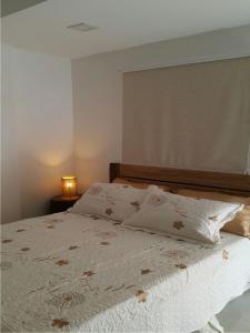 1 dormitorio con 1 cama blanca y 2 almohadas en Hospedaje solymar III Sarie Bay, en San Andrés
