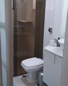 ein weißes Badezimmer mit Toilette und Waschbecken in der Unterkunft Apartamento em Enseada - Guarujá in Guarujá + 6 Fotos