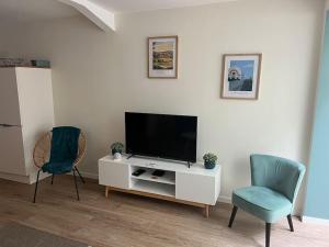 sala de estar con TV de pantalla plana y 2 sillas en Peace & Loire, en Cosne-Cours-sur-Loire