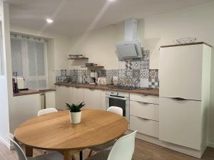 a kitchen with a table and a white refrigerator at Peace & Loire in Cosne-Cours-sur-Loire