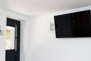 a flat screen tv on a wall next to a door at Titinas' in Plomari