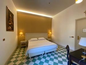 a bedroom with a bed and a checkered floor at Basilica Hotel in Rome
