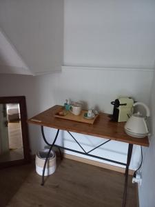 a wooden table with cups and appliances on it at Le Poisson Ivre in Dinan