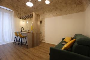 ein Wohnzimmer mit einer grünen Couch und einer Küche in der Unterkunft Dama Your Luxury Stay in Castellana Grotte