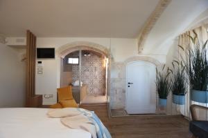 ein Schlafzimmer mit einem weißen Bett und ein Badezimmer in der Unterkunft Dama Your Luxury Stay in Castellana Grotte