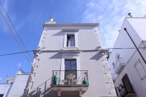 ein hohes weißes Gebäude mit einem Balkon in der Unterkunft Dama Your Luxury Stay in Castellana Grotte