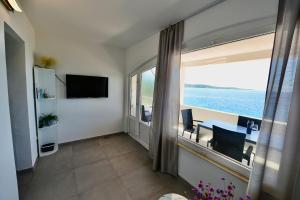 a living room with a table and a view of the ocean at Apartments Petarcica Beach in Zavala