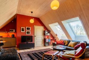 a living room with a couch and a tv at Ängaröds Gård in Ljungbyhed