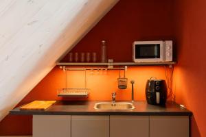 a kitchen with a sink and a microwave at Ängaröds Gård in Ljungbyhed