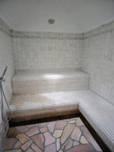 a tiled bathroom with a shower with avisor at Appartamenti Villa Flora by AMA Val di Fassa in Canazei