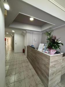an office lobby with a reception counter with a potted plant at Summer Beach Hotel in Polychrono
