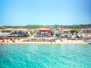 a beach with umbrellas and people on the beach at Summer Beach Hotel in Polychrono