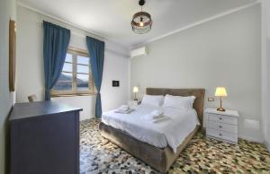 a white bedroom with a bed and a window at Villa Scoglio in Varenna