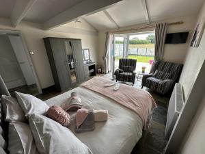 a bedroom with a bed with a stuffed animal on it at Dwylig Isa Holiday Cottages in Rhuddlan