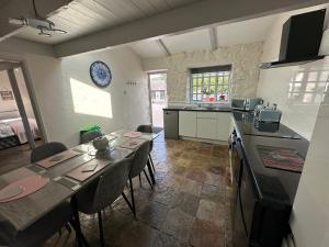 a kitchen with a table and chairs in a room at Dwylig Isa Holiday Cottages in Rhuddlan