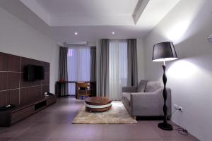 a living room with a couch and a chair and a lamp at Win D Hotel in Nakhon Ratchasima