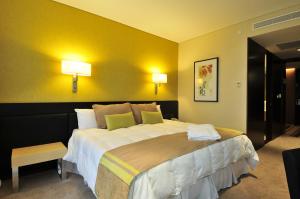 um quarto com uma cama grande e paredes amarelas em Rivera Casino & Resort em Rivera