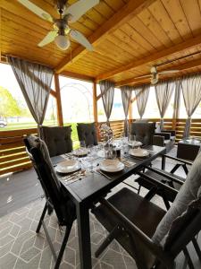 a dining room table with chairs and a ceiling fan at Mobile house T&N in Velenje