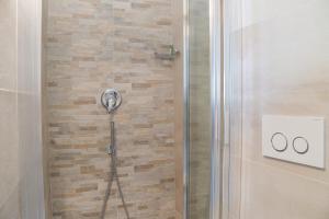 een douche met een douchekop in een badkamer bij KAMBUSA - Mono Fronte Mare in Santo Stefano al Mare