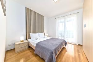 a bedroom with a bed and a large window at Apartmani Heta Alagic III in Selce