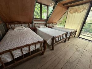 a bedroom with two beds in a room with windows at Yaxlik River Lodge in Lanquín