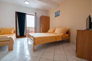 a bedroom with a bed and a television in it at Villa Nikola in Neum