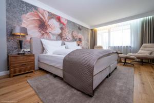 um quarto com uma cama com um quadro na parede em Waldhotel Luise em Freudenstadt