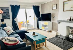 un soggiorno con un divano e una TV di Beautiful Beach Front Cottage ad Allonby