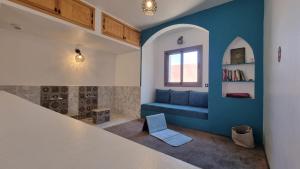 a living room with a blue couch and a window at Villa avec piscine Asilah, terrain de foot privative in Asilah