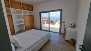 a bedroom with a bed and a large window at Villa avec piscine Asilah, terrain de foot privative in Asilah