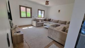 a living room with a couch and a table at Villa avec piscine Asilah, terrain de foot privative in Asilah