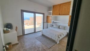 a bedroom with a bed and a door to a balcony at Villa avec piscine Asilah, terrain de foot privative in Asilah