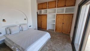 a bedroom with a large bed and wooden cabinets at Villa avec piscine Asilah, terrain de foot privative in Asilah