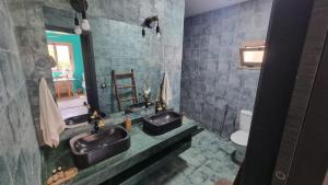 a bathroom with two sinks and a toilet at Villa avec piscine Asilah, terrain de foot privative in Asilah