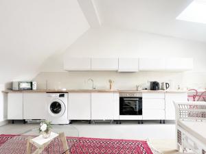 a kitchen with white cabinets and a washer and dryer at Place Sainte Marguerite in Provins